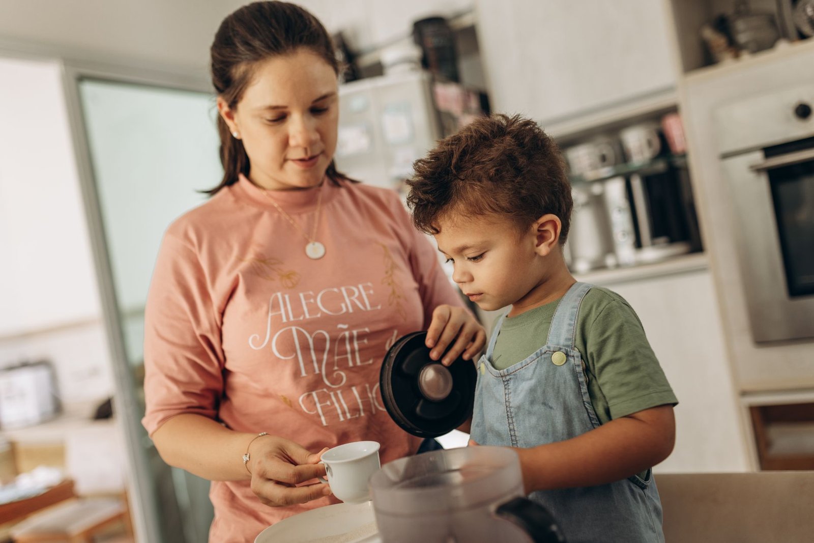 Mother helping child with schoolwork at kitchen table